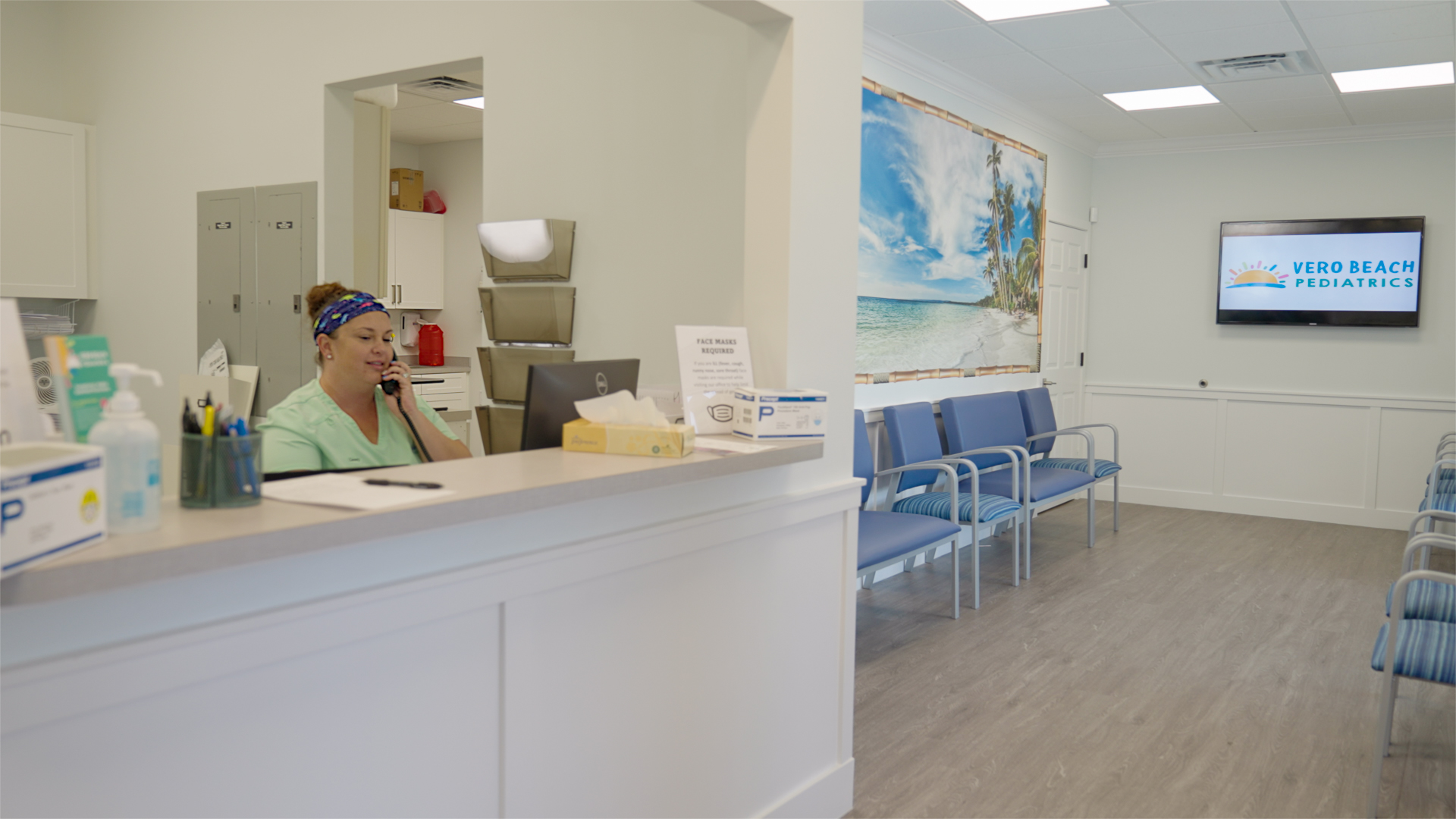 A friendly staff member welcoming families at the Vero Beach Pediatrics front desk